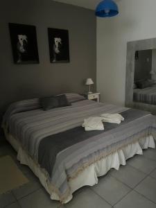 a large bed in a bedroom with two pictures on the wall at Departamento A&F II 1er piso Monoambiente 4 personas in San Fernando del Valle de Catamarca
