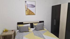 a bedroom with a bed and a table and a picture at Positive Apartment in Petrich