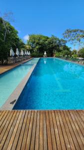 プライア・ド・フォルテにあるCasa em Praia do Forte Refúgio Luxo e Naturezaの大きな青いスイミングプール(ウッドデッキ付)