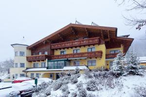 un gran edificio de apartamentos con nieve en el suelo en Haus am Hammerrain en Flachau