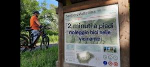 a man riding a bike next to a sign at Villa Luisa Appartamenti Vacanze in Caiolo