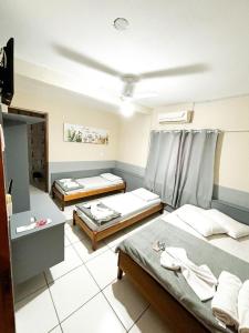 a room with three beds in a room at Pousada Parada Da Fé in Aparecida