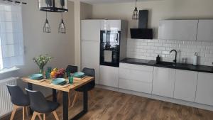 una cocina con una mesa de madera con sillas y un asterisco en Loftowe Zacisze nad Bałtykiem - 5 to the Sea, en Międzywodzie