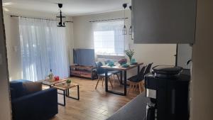 Una sala de estar con una mesa y un comedor. en Loftowe Zacisze nad Bałtykiem - 5 to the Sea, en Międzywodzie