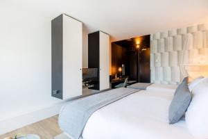 a bedroom with a large white bed and a television at Garner Hotel Maastricht by IHG in Maastricht +23 photos