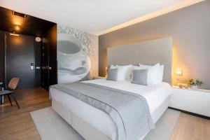 Un dormitorio con una gran cama blanca en una habitación. en Garner Hotel Maastricht by IHG, en Maastricht