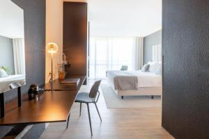 a hotel room with a bed and a desk and a bedroom at Garner Hotel Maastricht by IHG in Maastricht +105 photos