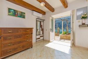 a large room with a dresser and a sliding glass door at Apartman Monkovic in Mokošica