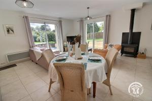 a dining room with a table and chairs and a living room at Mathilde in Lannion