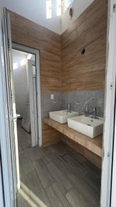 baño con 2 lavabos y paredes de madera en Las Villas Taxisco, en Taxisco 59 fotos más