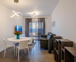 a living room with a table and a couch at Breathtaking Sea View by the beach in Anavyssos