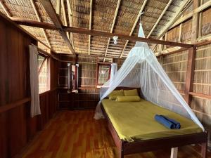 KriJunior Homestay的配有蚊帐的客房内的一张床位