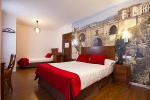 a bedroom with a large bed with a painting on the wall at Hotel El Tajo & SPA in Ronda +99 photos