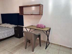 a room with a table and a chair and a bed at Comfortable room tajin in Coatepec