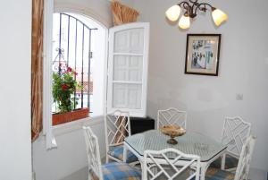 ein Esszimmer mit einem Tisch, Stühlen und einem Fenster in der Unterkunft Los Pinos 25 Villas Casasol in Nerja