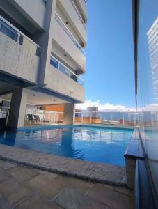 Apartamento Praia Grande caiçara في برايا جراندي: منظر لمبنى به حمام سباحة