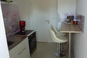 eine Küche mit einer Theke und 2 Hockern in der Unterkunft A&M-Wohnen in Ravensburg