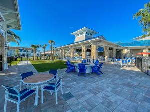 a patio with blue chairs and tables and a building at The Orlando Oasis in Davenport