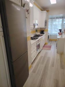 a kitchen with a stainless steel refrigerator and white cabinets at Lovely apartment in Cascais Park in Cascais