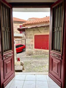 an open door to a garage with a red car at MOLAV Apartment in Mythimna +23 photos