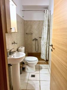 a bathroom with a toilet and a sink and a shower at MOLAV Apartment in Mythimna