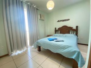 a bedroom with a large bed with a blue blanket at Movida cobertura Cabo Frio in Cabo Frio