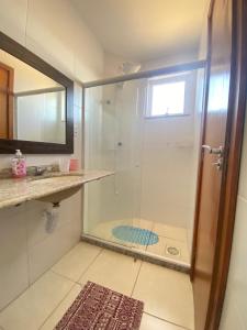 a bathroom with a shower with a glass door at Movida cobertura Cabo Frio in Cabo Frio