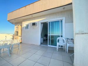 a patio with a table and chairs on a balcony at Movida cobertura Cabo Frio in Cabo Frio