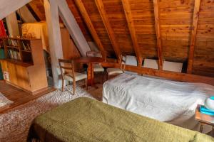 a bedroom with a bed and chairs in a cabin at Casa Vintage in San Carlos de Bariloche