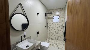 ein Badezimmer mit Waschbecken und Spiegel in der Unterkunft Hospedagem Café São Thomé in São Thomé das Letras + 12 Fotos