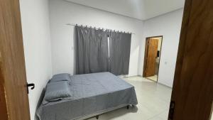 ein Schlafzimmer mit einem Bett in einem weißen Raum in der Unterkunft Hospedagem Café São Thomé in São Thomé das Letras