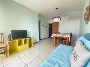 a living room with a television and a dining room at Movida Cabo Frio in Cabo Frio