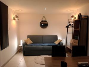 a living room with a couch and a clock on the wall at La Casa Beau site in Gap