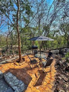 un patio con tavolo, sedie e ombrellone di Glamping El Cielo Adventures a Gómez Farías