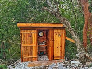 a wooden out house with a clock in it at Glamping El Cielo Adventures in Gómez Farías