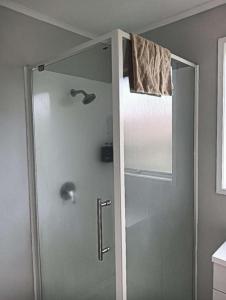 ロトルアにあるServed 3-Bedroom House A including 5 Double Beds, 1 Single Bed, and 2 King Sofa Bedsの浴室のガラス扉付きシャワー +15枚の写真