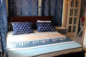 - une chambre avec un lit aux murs bleus et des oreillers dans l'établissement Green House, 1bdr Apt, 7 min from Airport, à Accra