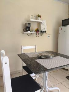 a kitchen with a table and two white chairs at Espaço Vendrame in Criciúma +1 photo