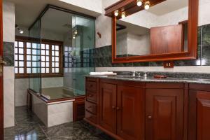 a bathroom with a glass shower and a sink at Casa das Montanhas - Aconchego e Tranquilidade à 2,4km do Capivari in Campos do Jordão