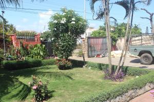 un jardin avec un arbre et des fleurs dans une cour dans l'établissement Green House, 1bdr Apt, 7 min from Airport, à Accra