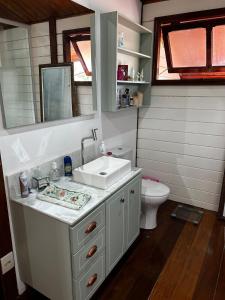 a bathroom with a sink and a toilet at Casa Raízes - Atibaia in Atibaia