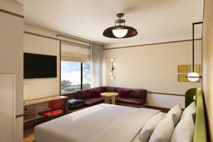 a hotel room with a bed and a couch at The Tallison Hotel, a Tribute Portfolio Hotel in Carmel