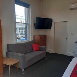 a living room with a couch and a flat screen tv at Hope Street Apartments in Dunedin +98 photos