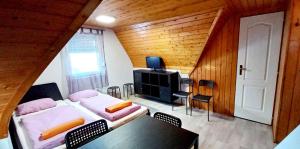 a room with two beds and a table and a tv at Holiday home in Zamardi - Balaton 53551 in Zamárdi