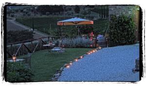 a garden with an umbrella and a table and chairs at Tenuta San Pietro Luxury Hotel in Lucca