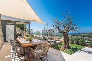 a table and chairs on a patio with a tree at Holiday home in Merisce - Istrien 53394 in Merišće