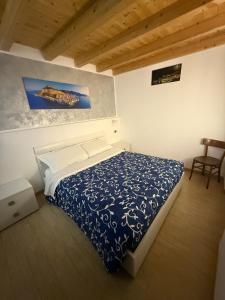 sypialnia z łóżkiem z niebiesko-białą kołdrą w obiekcie Relax house w Cefalù