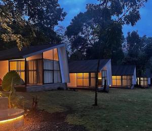 a house with two buildings in a yard at night at villa heve glamping in Kaliurang