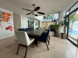 a dining room with a table and chairs at Casa La Ceiba in Cancún