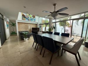 a dining room with a table and chairs and a ceiling fan at Casa La Ceiba in Cancún